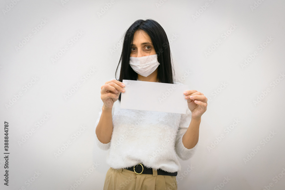 Young caucasian woman with tired and exhausted eyes holds in hands showing white envelope with blank space. Concept of overworking or tiredness of corona virus Young caucasian woman with tired and exhausted eyes holds in hands showing white envelope with blank space. Concept of overworking or tiredness of corona virus