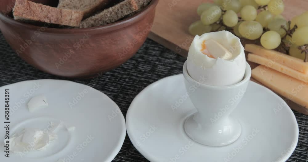 Person eating soft boiled egg for breakfast	

