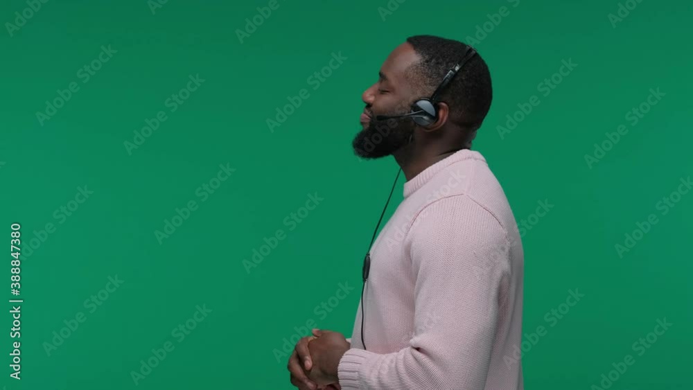 Smiling african american man wearing wireless headset talking to microphone isolated on Green Screen, Chroma Key, customer service agent Smiling african american man wearing wireless headset talking to microphone isolated on Green Screen, Chroma Key, customer service agent