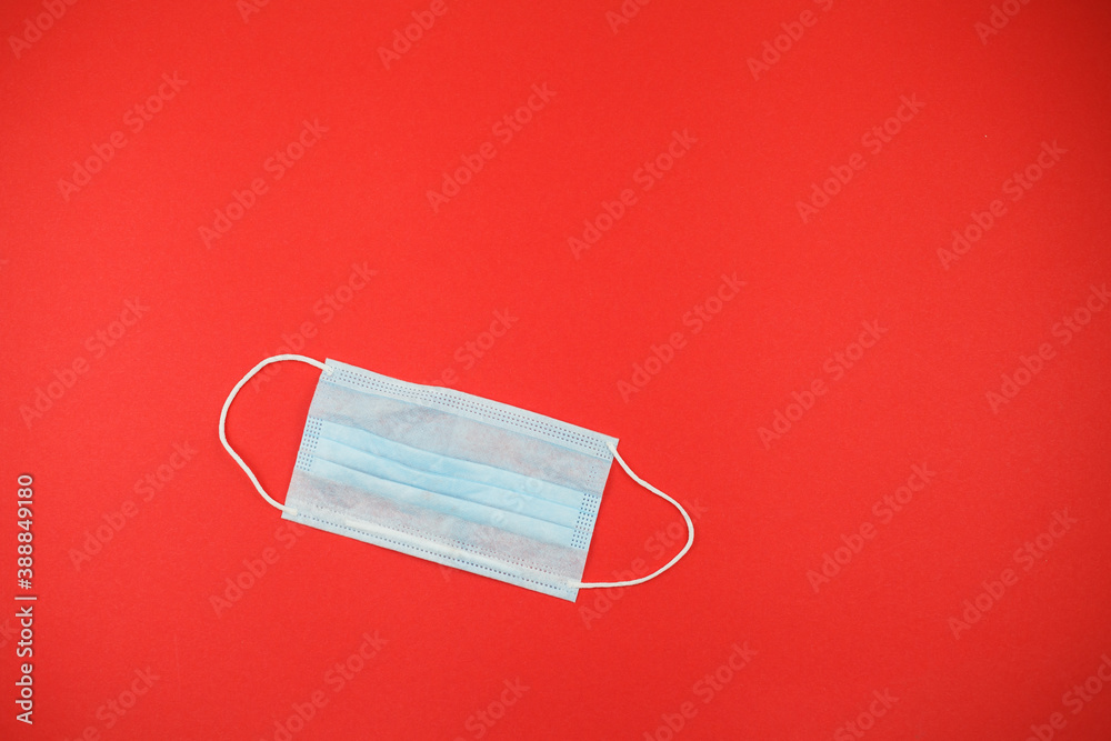 Medical face mask on a red background. Covid during Christmas season concept. Medical face mask on a red background. Covid during Christmas season concept.