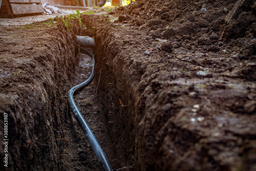 Water and sewer pipes in a digged trench deep in the ground. Sewerage and water system repair concept.