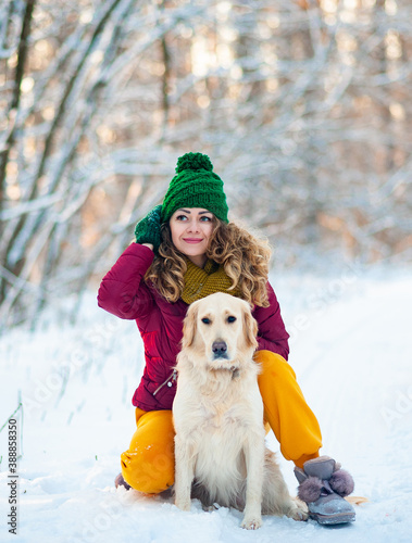 Image of young girl with her dog white golden retriever hugging, outdoor at winter time. Domestic pet. woman playing with dog. Closeup portrait © trofalena