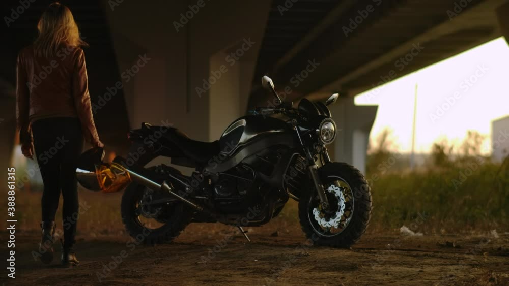 Biker Woman Walking Through Parking to his Standing Motorcycle in City. Conception Motorcyclist and Motorbike. Back Side View Sexy Girl Driver in Urban Lifestyle Scene Autumn Video Shooting Slow mo 4k