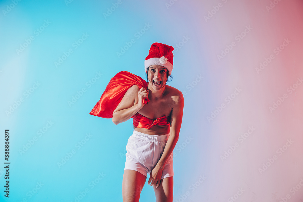 Obraz premium Beautiful female model wear santa hat. Sensual. Smile woman. Christmas time. Gifts. Happy day. 