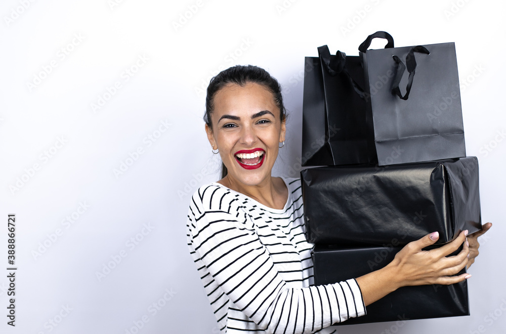 Young beautiful woman holding black shopping bags and boxes smiling. Black Friday Young beautiful woman holding black shopping bags and boxes smiling. Black Friday