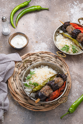 Kebabs with rice pilav and baked vegetables on copper pan. copy space