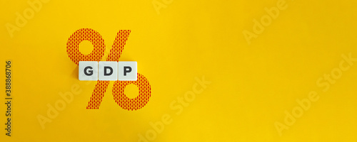 Gross Domestic Product (GDP) fall and Economic Recession Concept and Banner. Block letters, Percentage Sign and Red Down Arrows on bright yellow orange background. Minimal aesthetics. photo
