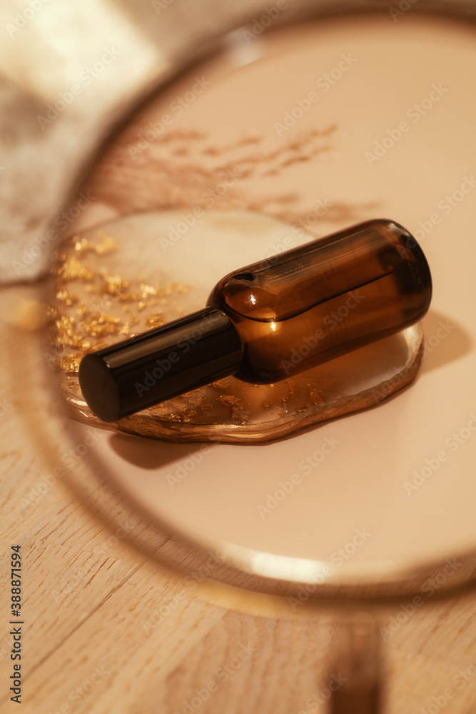Brown glass cosmetic bottle on warm nude  in the miror