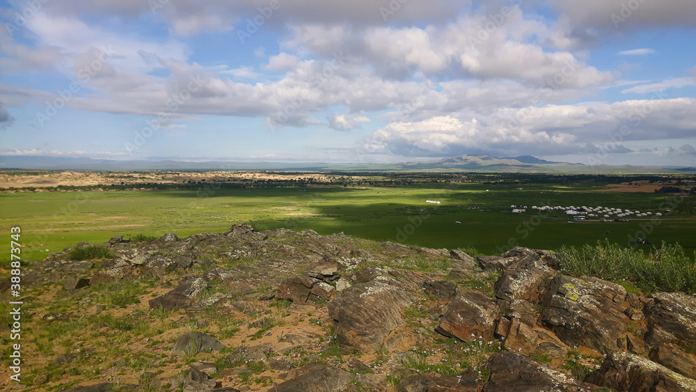 Dramatic vast expanse of rural Mongolia compromised of grassy plains, sand dunes and rocks