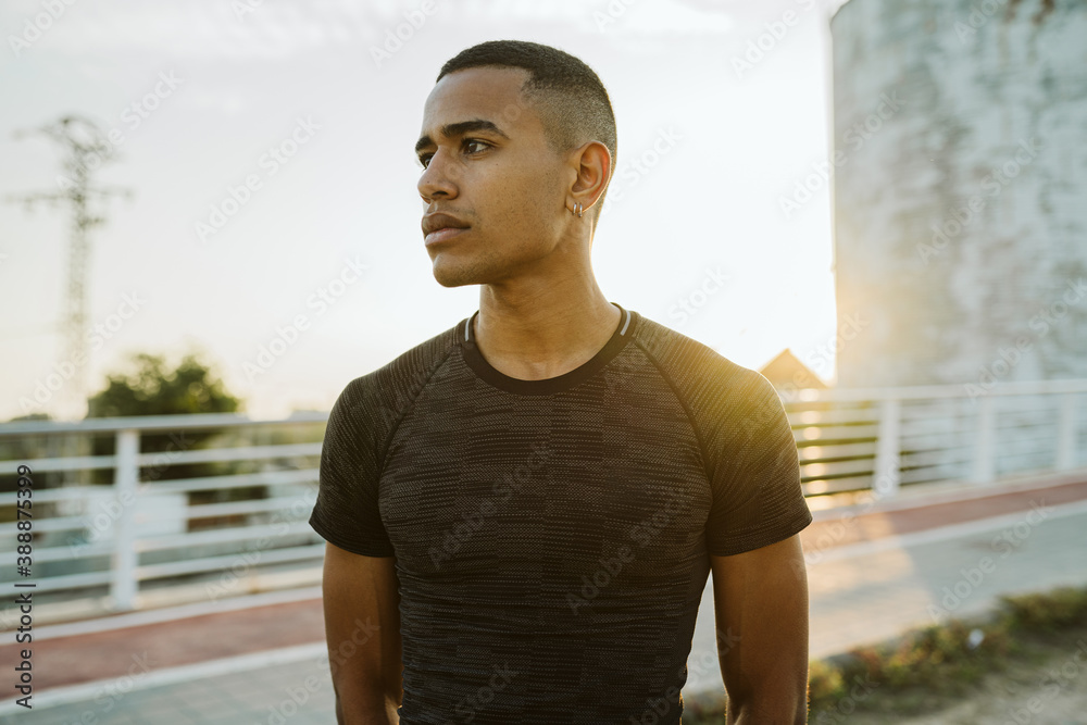 Serious black athlete near silo Serious black athlete near silo