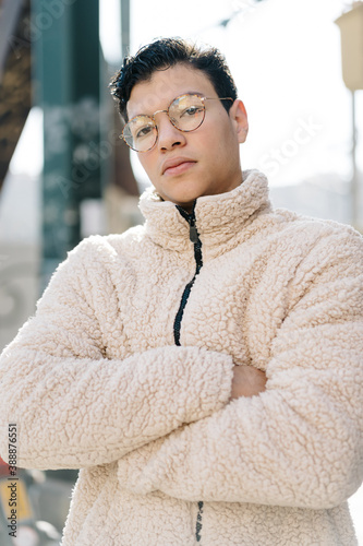 Confident Asian man in fleece jacket on street photo