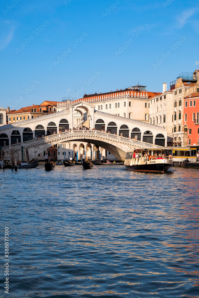 Gondolier, Rialto Bridge and Tourists at Gondolas in Grand Canal with Traditional Venetian Colorful Houses - Quiet Morning in Venice, Veneto, Italy