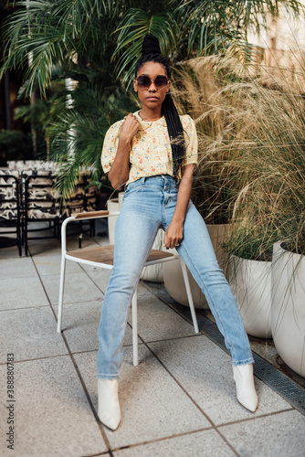 Woman styling blue jeans with yellow top and white boots photo