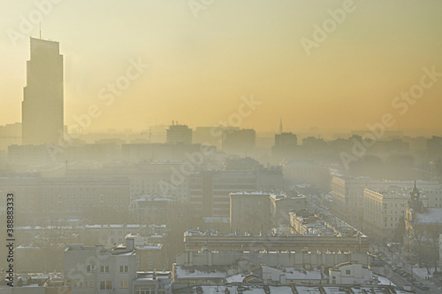 View of a modern cityscape covered in a dense smog and pollution, during sunset