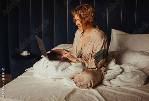 Young woman in pajama working on laptop