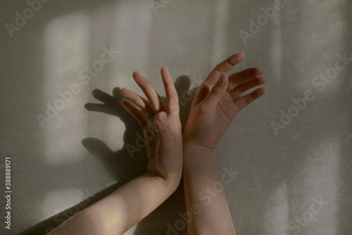 girl's hands with evening soft light on a neutral background