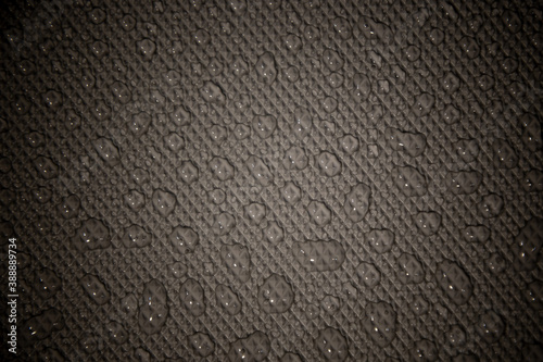 wet with water drops dark grey background with geometrical texture and gradient illumination, closeup, details