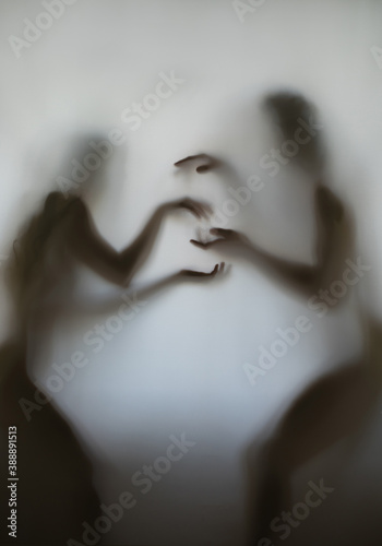 silhouette of a guy and a girl behind the fabric in very beautiful poses photo