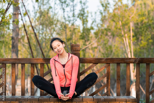 A Chinese beauty is exercising outside and listening to music photo