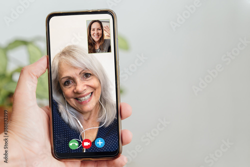 Obraz na plátne Happy senior and daughter talking on video call with mobile phone during coronav