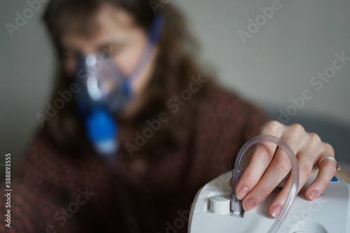 A young sick woman doing inhalation at home photo