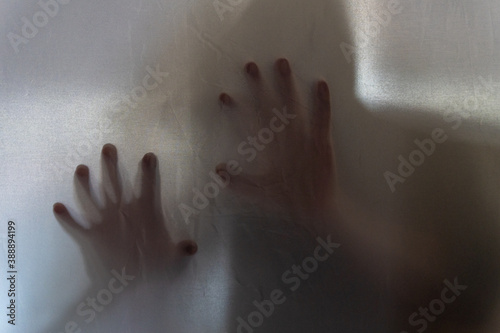 A spooky hooded figure holding his hand ups
