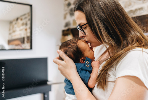 Mother kissing baby on forehead photo