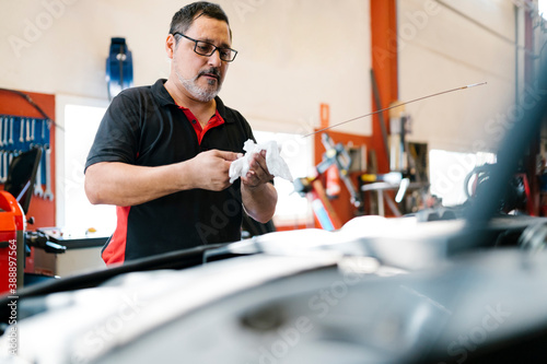 Male mechanic repairing car in auto repair shop photo