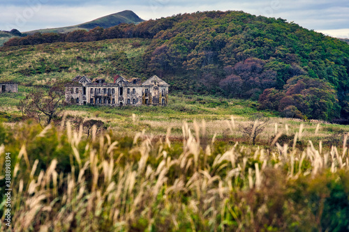 Abandoned building on green landscape at Novgorodskaya bay, Primorsky region, Russia photo