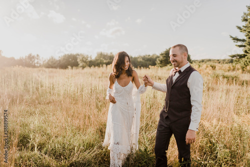 Couple holding hand and walking in field on sunny day