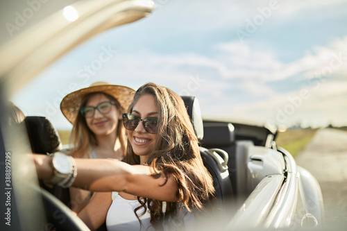 Smiling young friends traveling on sunny day