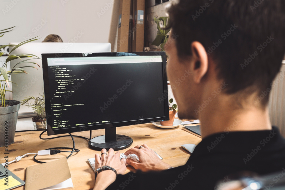 Computer programmer coding on desktop at workplace Computer programmer coding on desktop at workplace
