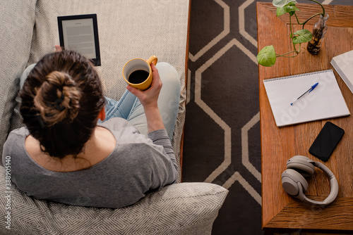 Konstfotografi Woman reading e-book while drinking coffee