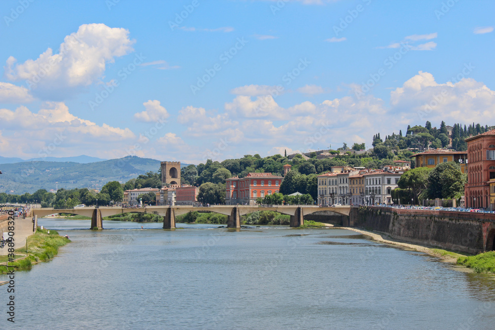 View down a river in Florence, Italy with bridge in the distance. No people, space for copy.