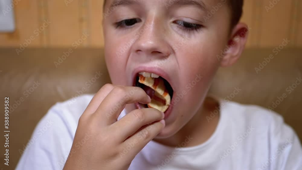 Hungry Caucasian Teen Puts Chips in Mouth with Hand. Boy Eats Fast Food. Hungry Caucasian Teen Puts Chips in Mouth with Hand. Boy Eats Fast Food.