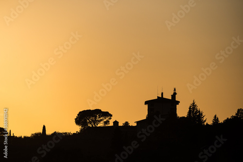 Silhouette of a house and a tree seen from Piazzale Michelangelo right before sunset. Florence, Italy.