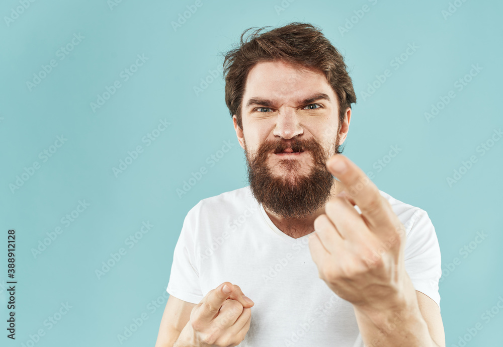 Model bearded man in white T-shirt on blue background irritability emotions model Model bearded man in white T-shirt on blue background irritability emotions model