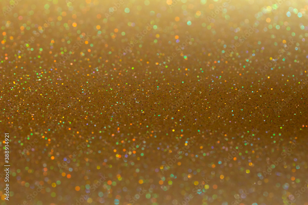 Full frame macro abstract background of sparkling gold color glitter texture, with bokeh and copy space