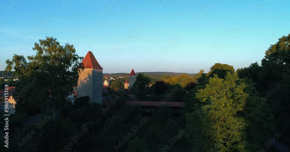 a drone flies in the park on the left you can see the old historic town on the right trees in front covered footbridge a drone flies in the park on the left you can see the old historic town on the right trees in front covered footbridge