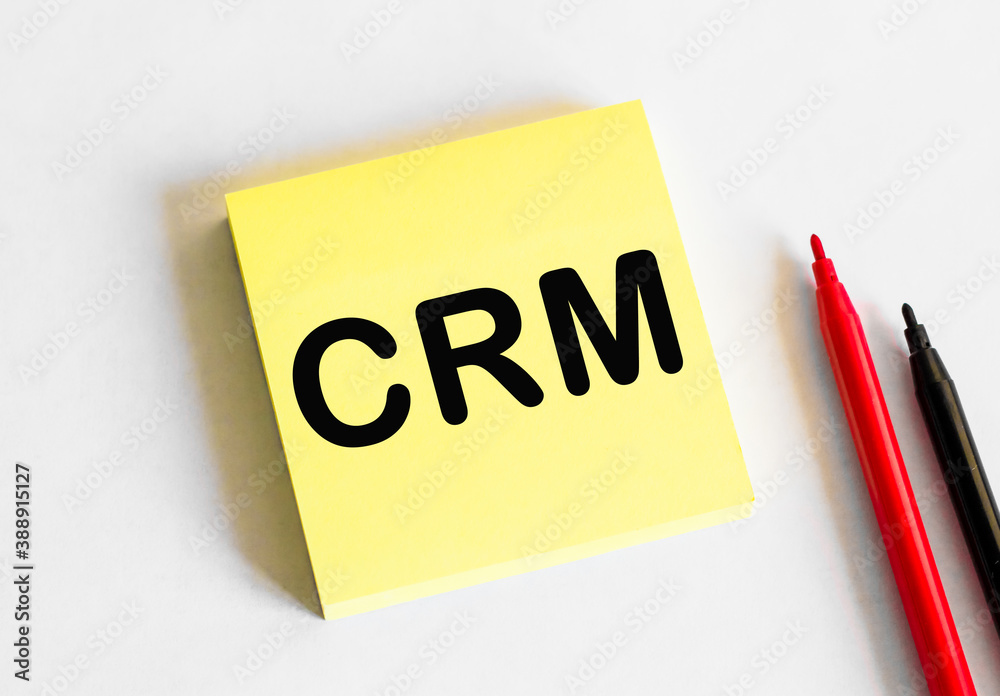 CRM. The text is written on a yellow sheet. The markers and sheets of paper are on the table. CRM. The text is written on a yellow sheet. The markers and sheets of paper are on the table.