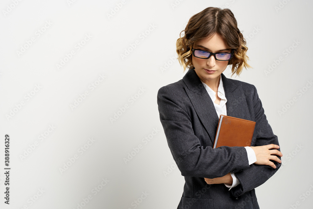 Business woman in a classic suit with a notebook in her hand and glasses on her face Copy Space Business woman in a classic suit with a notebook in her hand and glasses on her face Copy Space