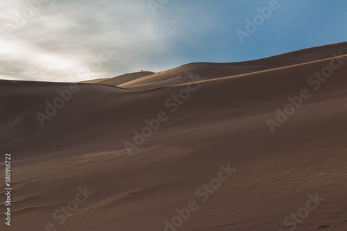 Climbers Watching Sunset on The Dune Field of Great Sand Dunes National Park  Colorado  USA