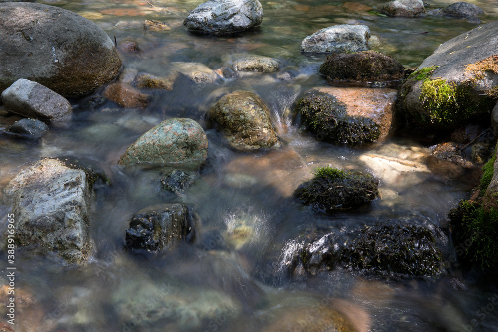 Slow shot of the clear stream flowing in the outdoor mountain Slow shot of the clear stream flowing in the outdoor mountain