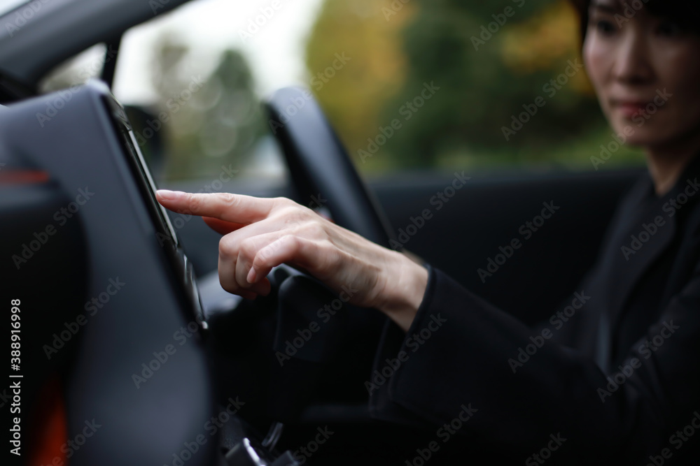 運転中にカーナビを操作する女性 運転中にカーナビを操作する女性