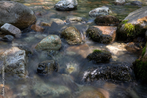 Slow shot of the clear stream flowing in the outdoor mountain