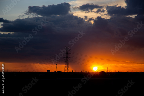 High voltage poles, light and evening light at sunset.