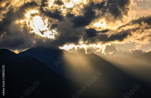 Mystical mood with sun behind dark clouds, sun rays falling over a dark mountain, Colombia