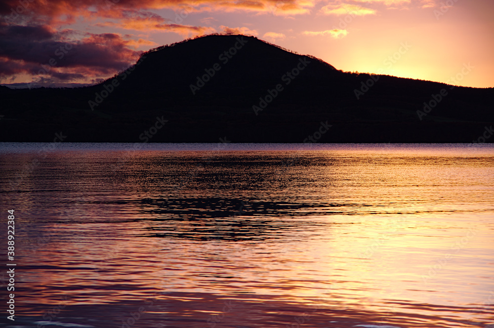 トワイライトのカルデラ湖。湖面に反射する空の光。屈斜路湖、北海道、日本。