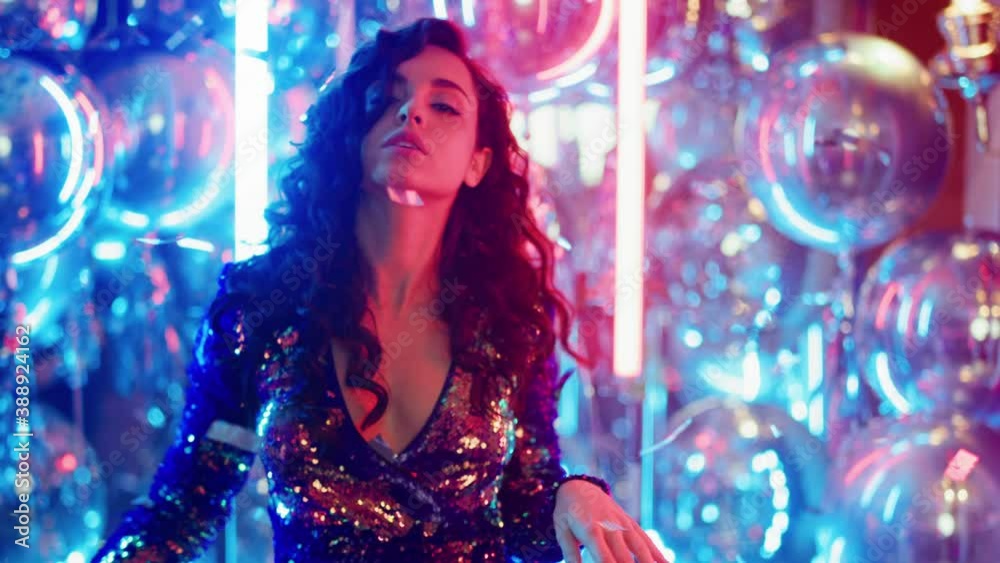 Fancy woman having fun at party. Sexy girl dancing on neon lamps background
