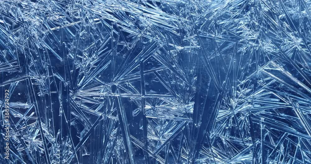 Frost covered window with lights shimmering and glittering over ice crystals.